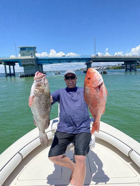 A grouper and a red snapper, one in each hand.