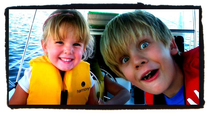 Two small crew in life jackets, underway.