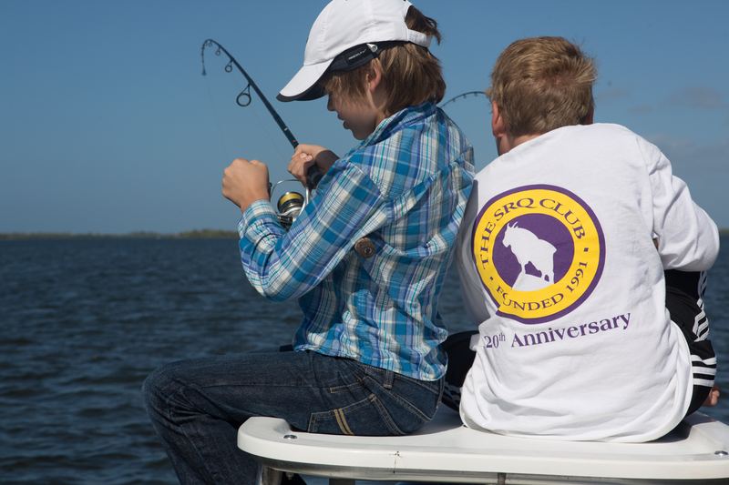 Kids fishing light tackle on an inshore charter — pack snacks, a towel, and children's motion meds