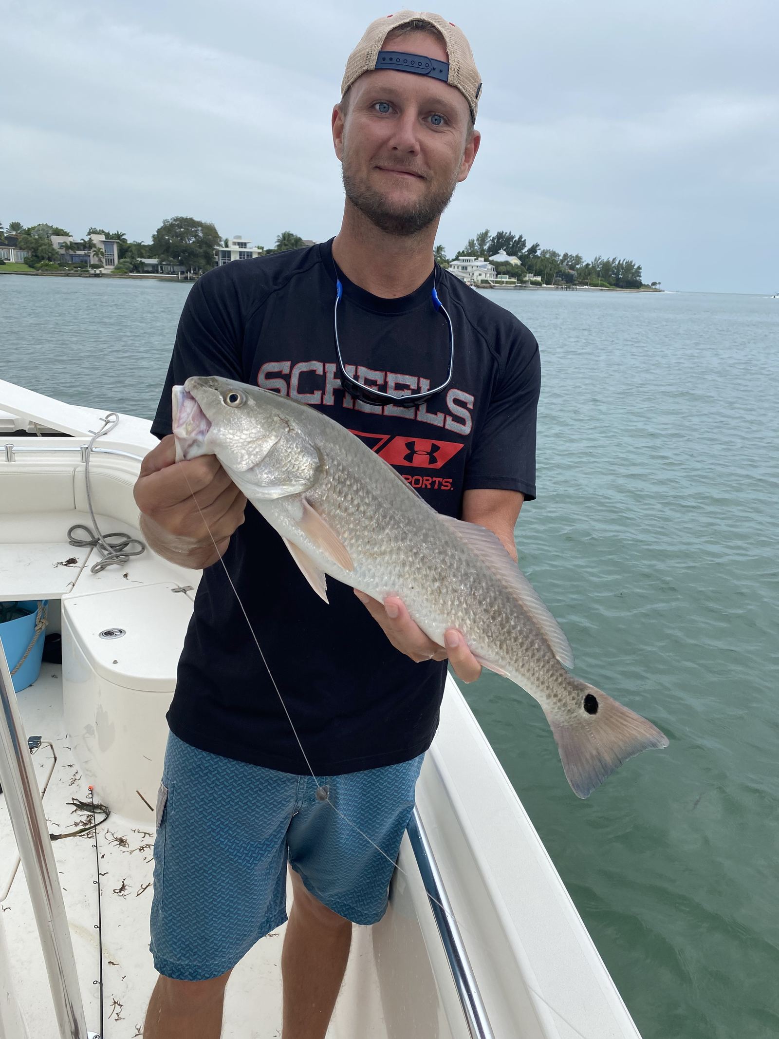 An angler with a slot Sarasota redfish on the flats