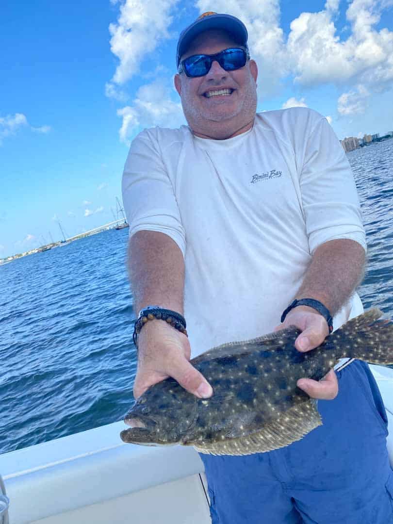 Flounder slide out of the bay toward the passes in the fall, stacking on sand edges ahead of their offshore winter spawn.