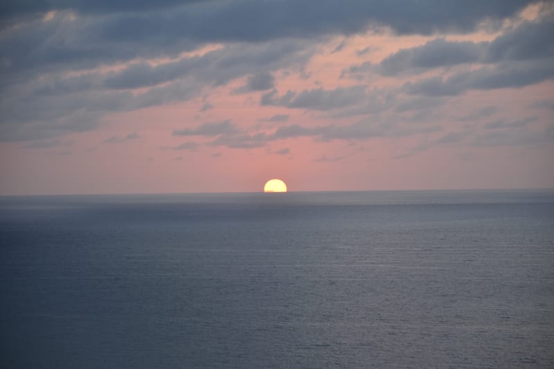 The sun clearing the horizon over open water.